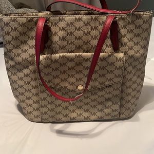 Michael Kors shoulder bag with red handle straps.